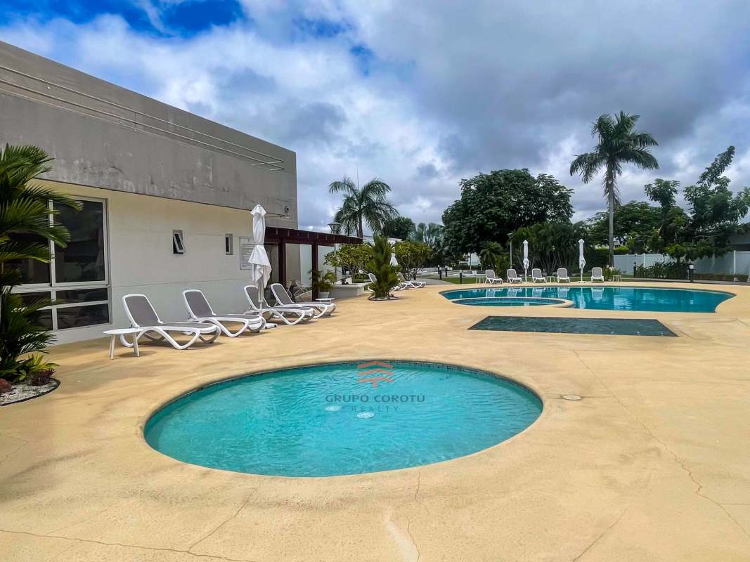 Luxury swimming pool with palm trees and lounge areas at Costa Sur gated community Panama