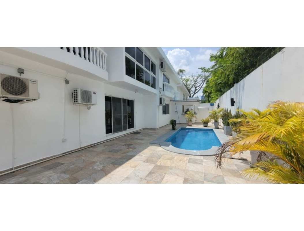 Private outdoor pool surrounded by modern patio, planters and white walls in Altos del Golf Panama City luxury house