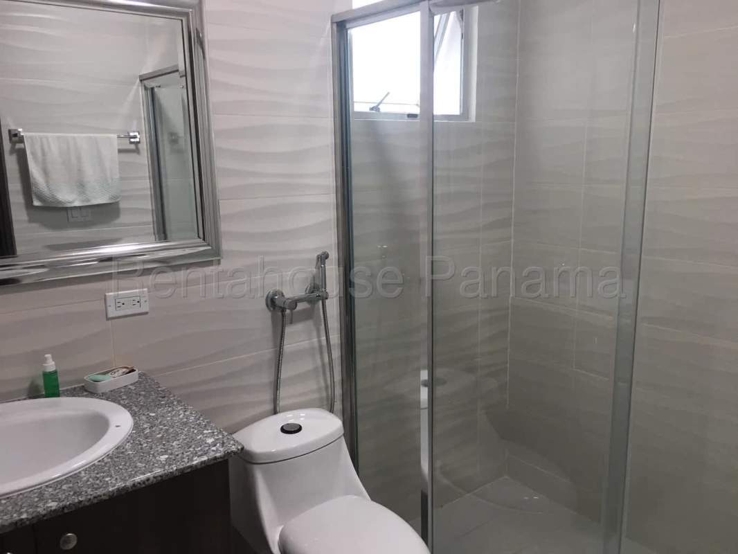 Bathroom with granite vanity, glass shower enclosure and tile accents in PH Trinity El Cangrejo Panama