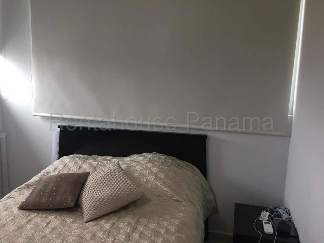 Bedroom with roller shades, neutral tones, nightstand and bed PH Trinity El Cangrejo Panama