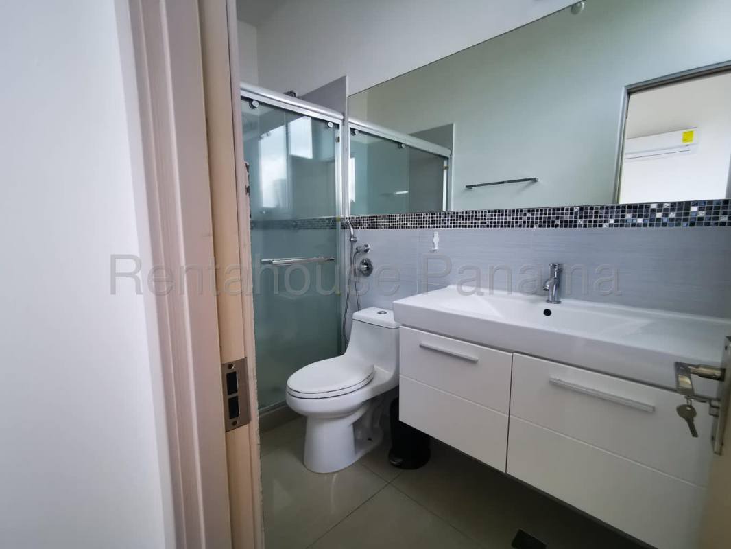 Bathroom with glass shower enclosure, large mirror in PH Rainbow Tower Panama