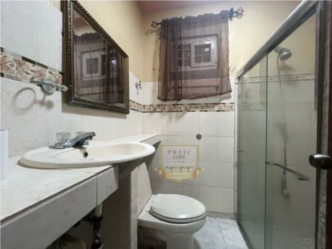 Traditional bathroom with glass shower, sink, wall mirror, curtain window Tocumen Panama