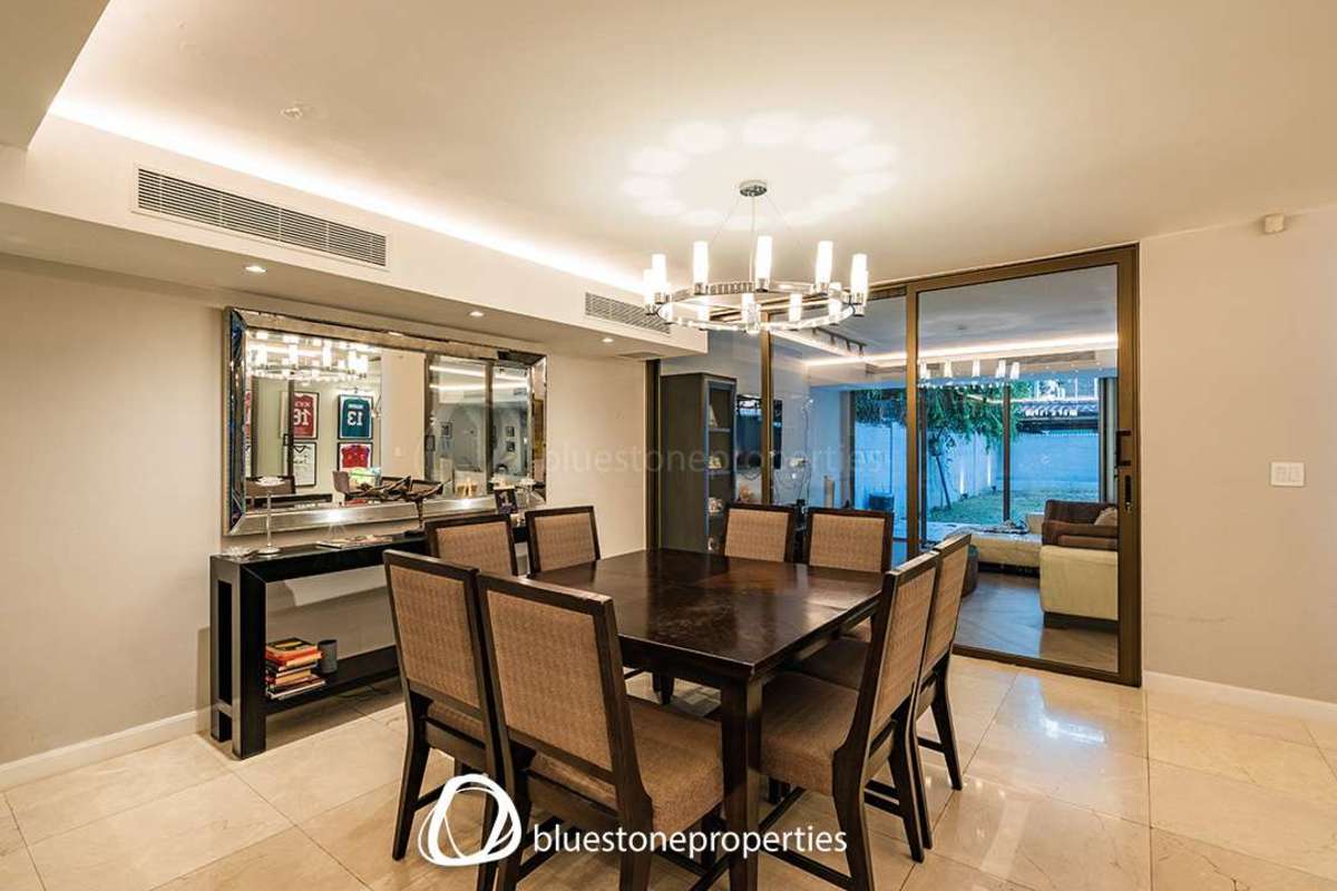 Contemporary dining room with chandelier and sliding glass door in Punta Paitilla home