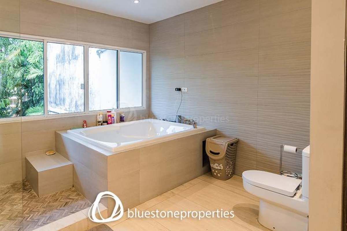 Spacious bathroom with large tub, shower, and window in Punta Paitilla residence