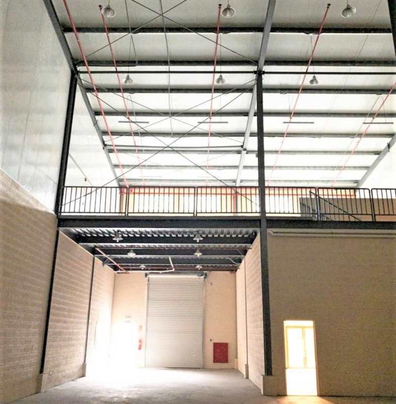 Interior of warehouse with mezzanine and large industrial roller shutter door for rent in Via Tocumen Panama