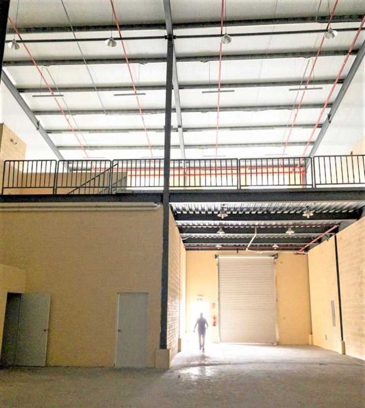 Empty industrial warehouse with high ceilings, mezzanine storage and large rolling door in Panama City