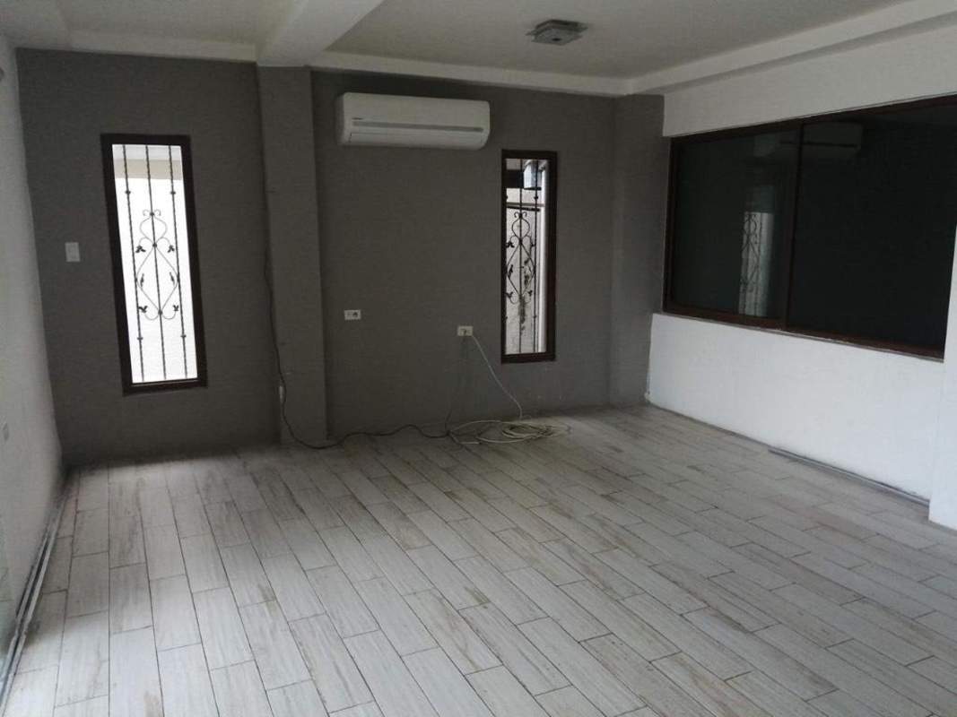 Backyard with wood deck, lawn, garden lights, white walls in Residencial San Isidro Panama City