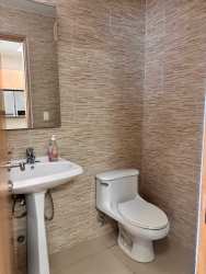 Modern bathroom with beige wall tile, sink and mirror PH Cocoli Bijao Panama