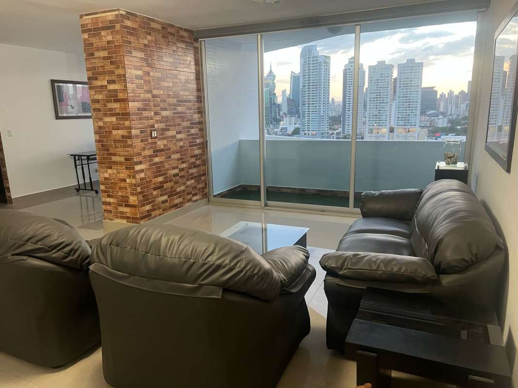 Modern dining room with glass table, brick accent wall and air conditioning in Infinity Tower San Francisco Panama