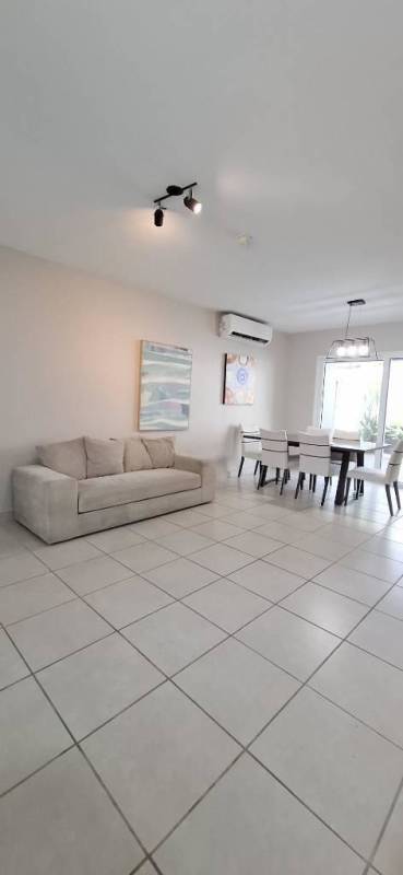 Open living and dining area with sofa, table and large window PH Victoria Panama