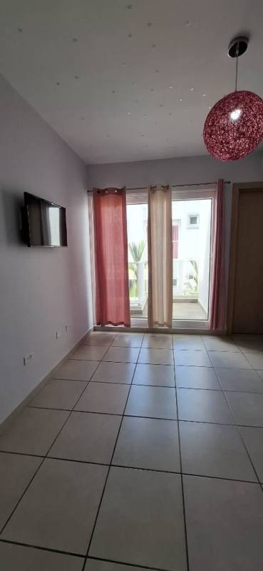 Minimalist bright living room with TV, balcony windows and curtains in PH Victoria Panama