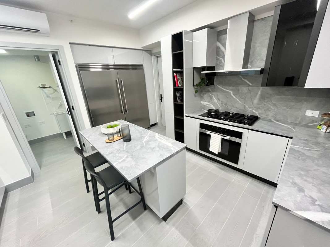 Modern kitchen with marble counters, built-in appliances PH The Ivy Santa Maria