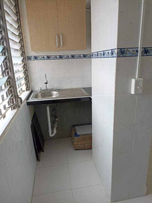 Compact laundry area with sink, cabinet and ventilation window in Santa Ana Panama apartment
