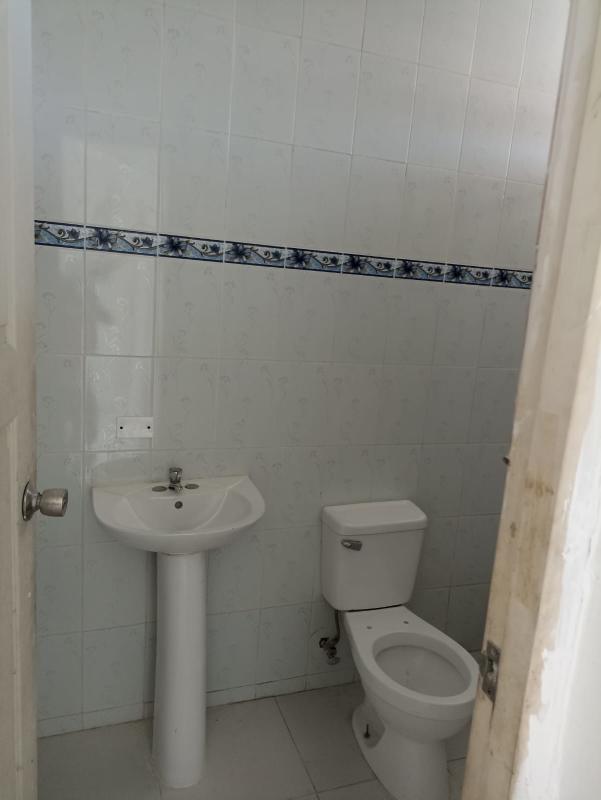 Simple bathroom with ceramic tiles, pedestal sink and blue tile accents in Santa Ana Panama City apartment for sale