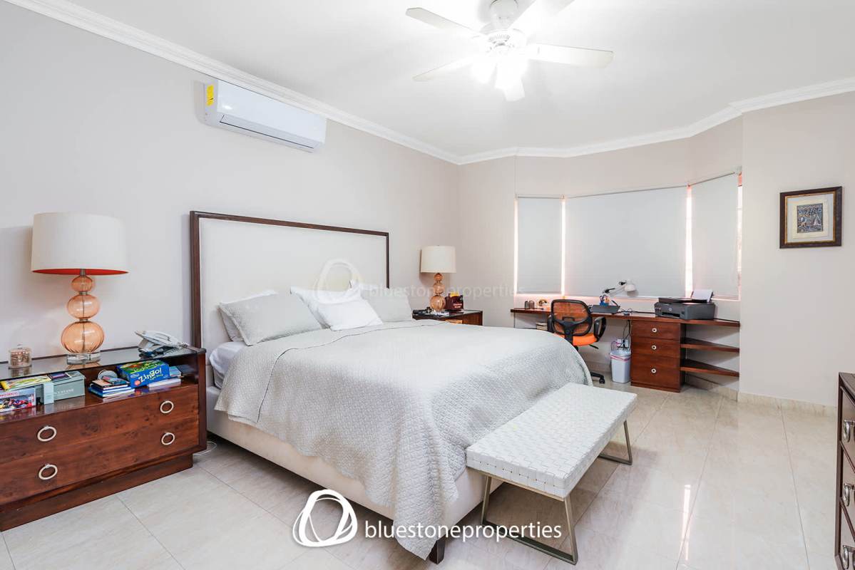 Backyard swimming pool with covered patio and lush garden in luxury house Costa del Este Panama