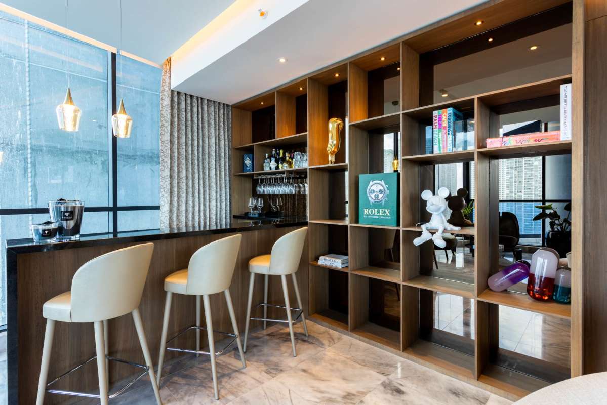 Home bar lounge with wooden shelving, pendant lights and city views PH Ocean Front Punta Paitilla