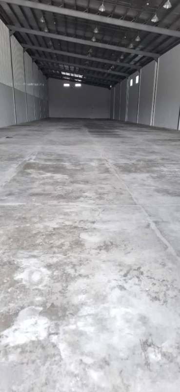 Large empty warehouse interior with concrete floor and metal roofing near Panama City Airport
