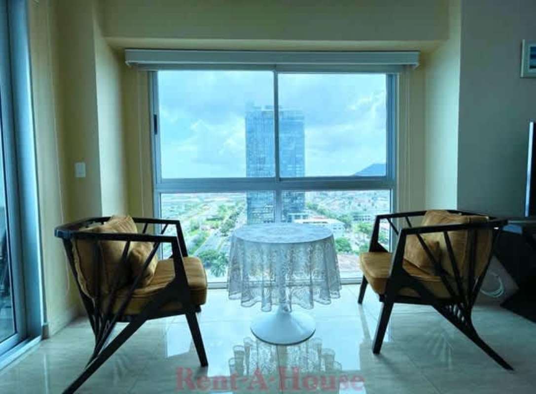 Corner living space with large window overlooking Panama skyline PH Yacht Club Panama