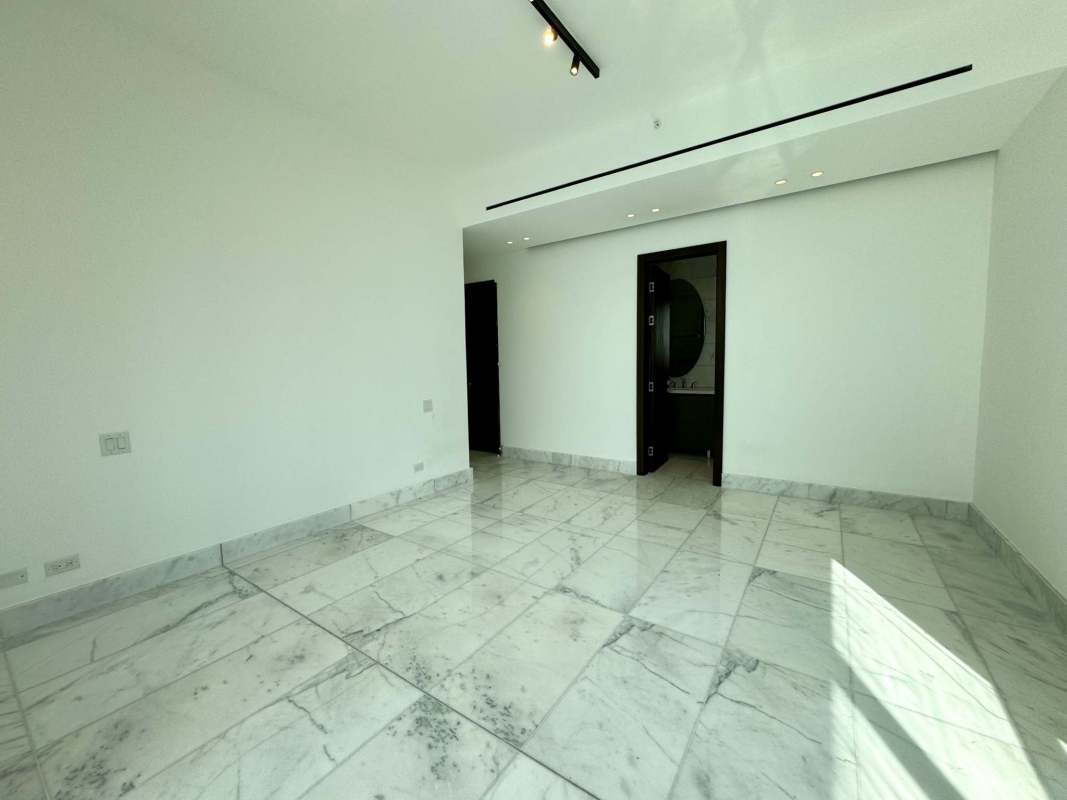 Spacious master bathroom with marble tiles, double sink vanity and glass shower in PH Sea Point Punta Paitilla Panama