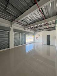 Empty commercial unit with exposed industrial ceiling polished floors glass windows in La Chorrera Costa Verde