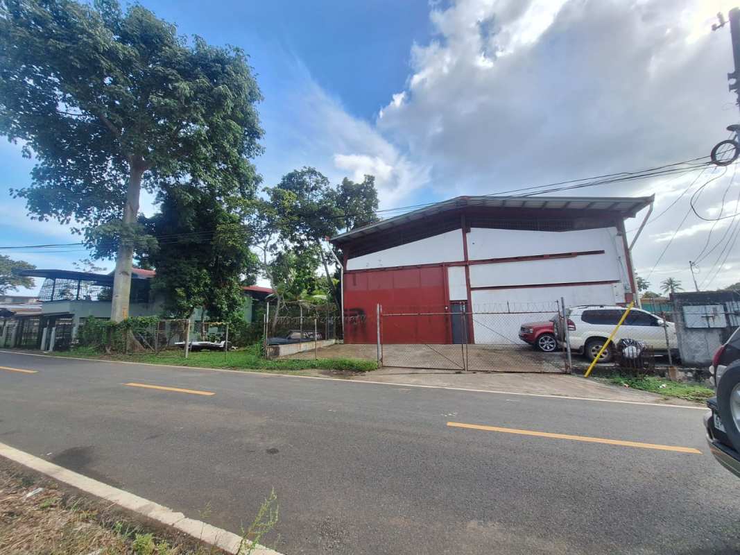 Exterior view fenced industrial warehouse large metal door asphalt street Las Acacias Juan Diaz Panama