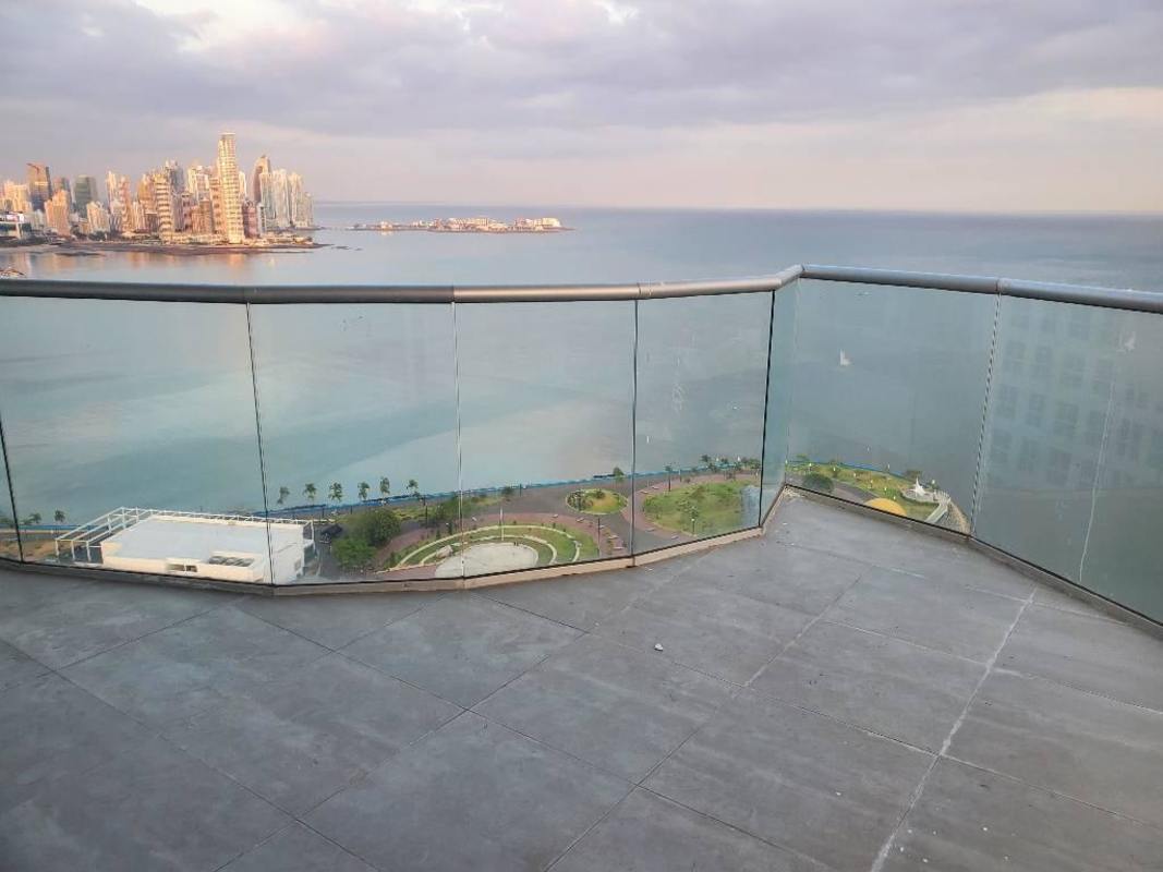Corner L-shaped balcony with glass railing overlooking ocean and skyline PH The Sands Panama