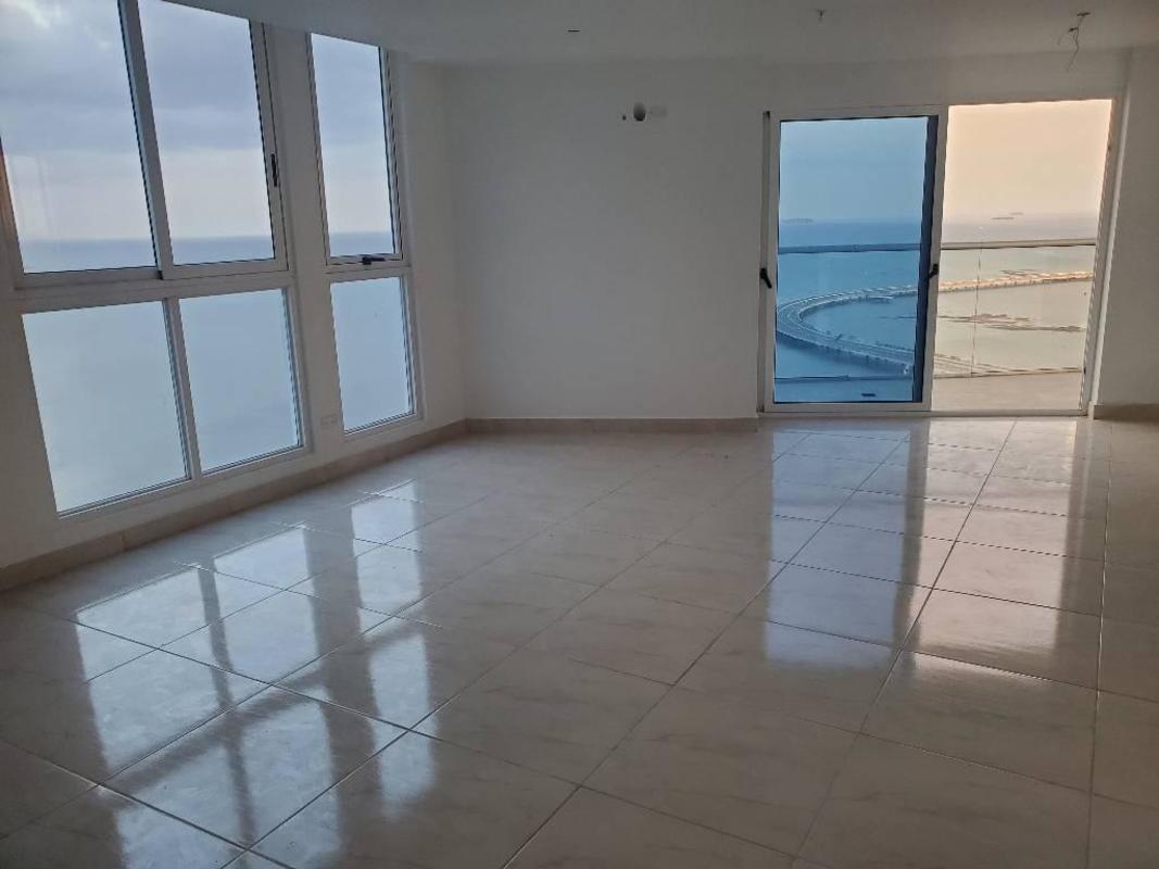 Living room with large window offering Pacific Ocean and city skyline view in PH The Sands