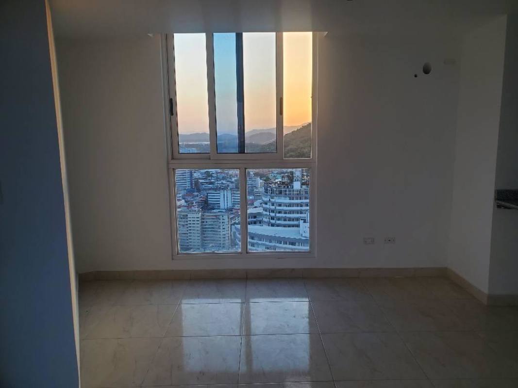 Bright empty living space large window city skyline and sunset views in PH The Sands