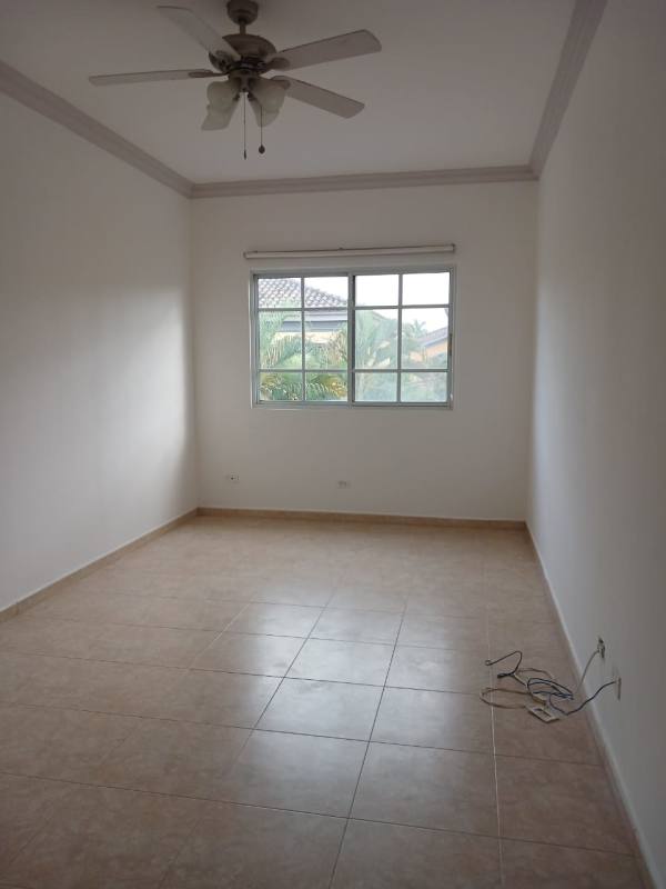 Bedroom with large window, ceiling fan and ceramic tile floor in modern Costa del Este rental house Panama