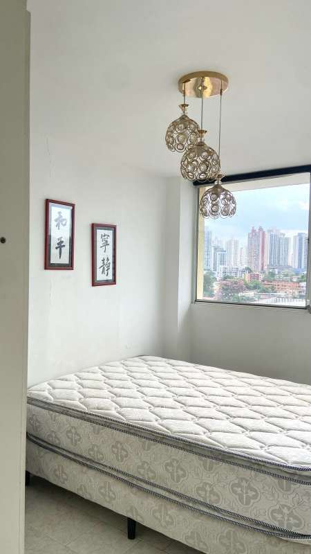 Furnished bedroom with large window, split AC and skyline view in PH Park Place Panama City