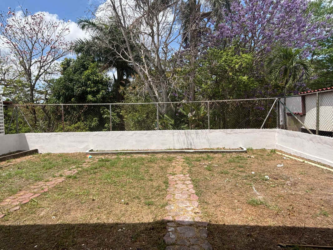 Spacious kitchen with white cabinets, granite counters, double sink at Panama rental house