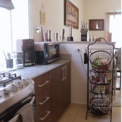Modern kitchen with granite counters, gas stove, and ample natural light at Arboledas Costa Verde Panama