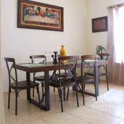 Modern kitchen corner with range hood, brown cabinets, and window at Los Álamos La Chorrera