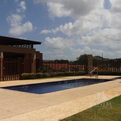 Large grassy backyard with covered patio area and garden in La Chorrera Panama