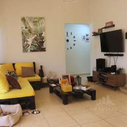 Living room space with sectional sofa and wall-mounted TV in house for rent La Chorrera Panama