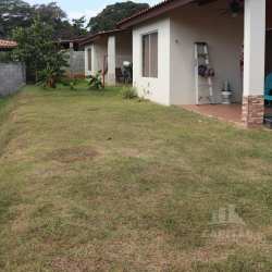 Covered backyard patio with chairs and sliding glass doors at Los Álamos Arboledas Panama