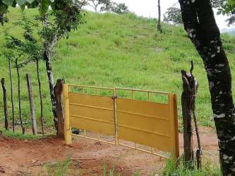 Yellow gate and fenced entry to farmland in Soná Veraguas Panama