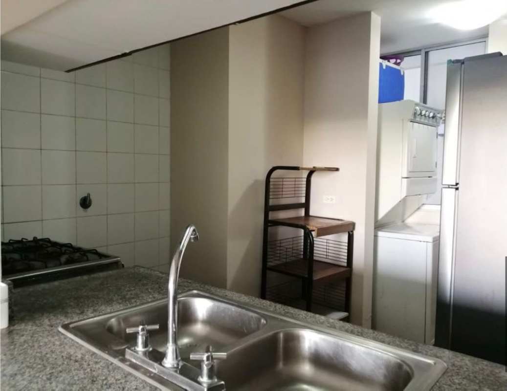 Bedroom with minimalist style gray tufted headboard and porcelain tiled floor PH La Loma Panama