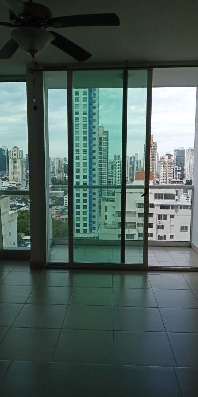 Bright living room with sliding glass to balcony overlooking city skyline at PH San Francisco