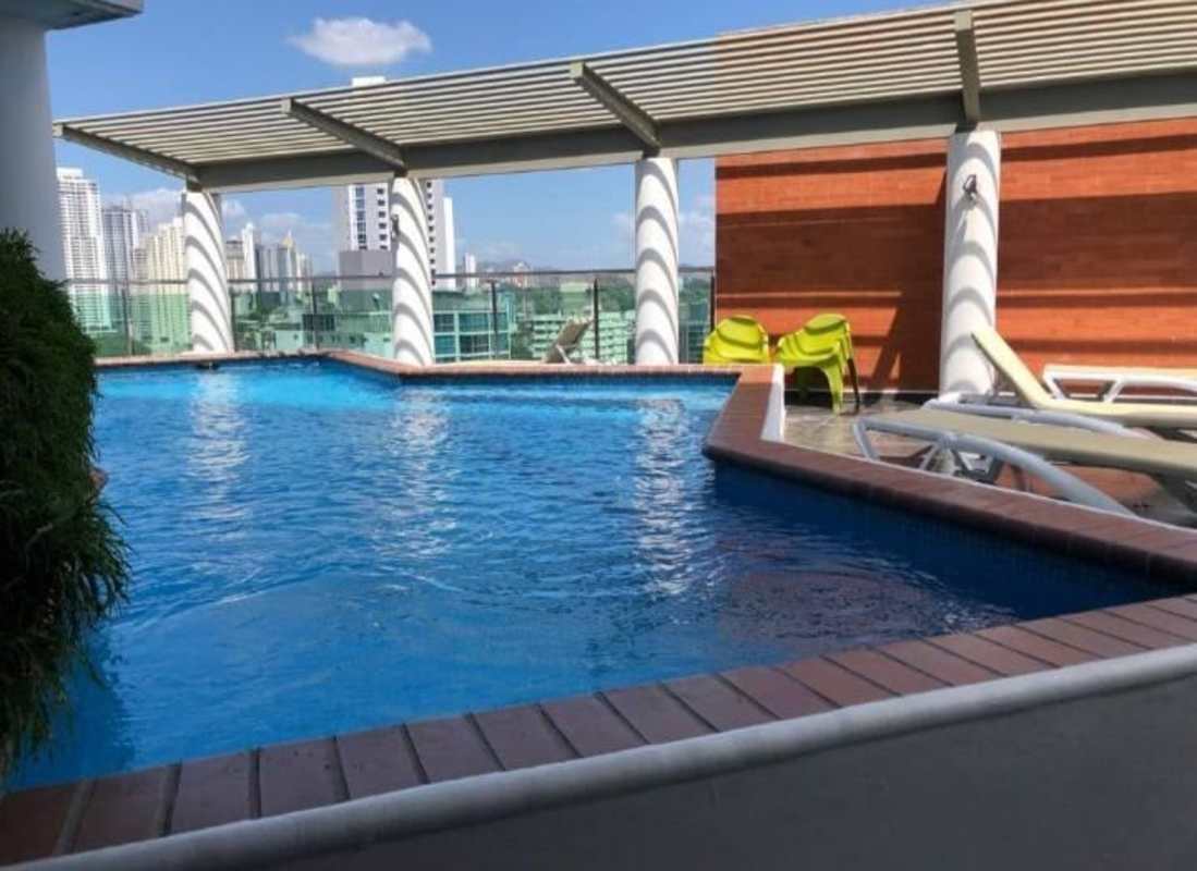 Bright living room with turquoise sofa, wooden floors, balcony access in PH Vista Hermosa Via Argentina Panama