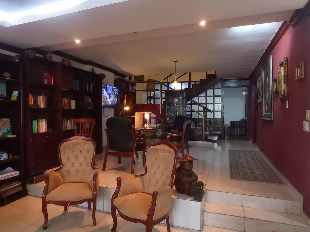 Covered outdoor terrace with garden view at 3-story Los Ángeles El Dorado house for sale