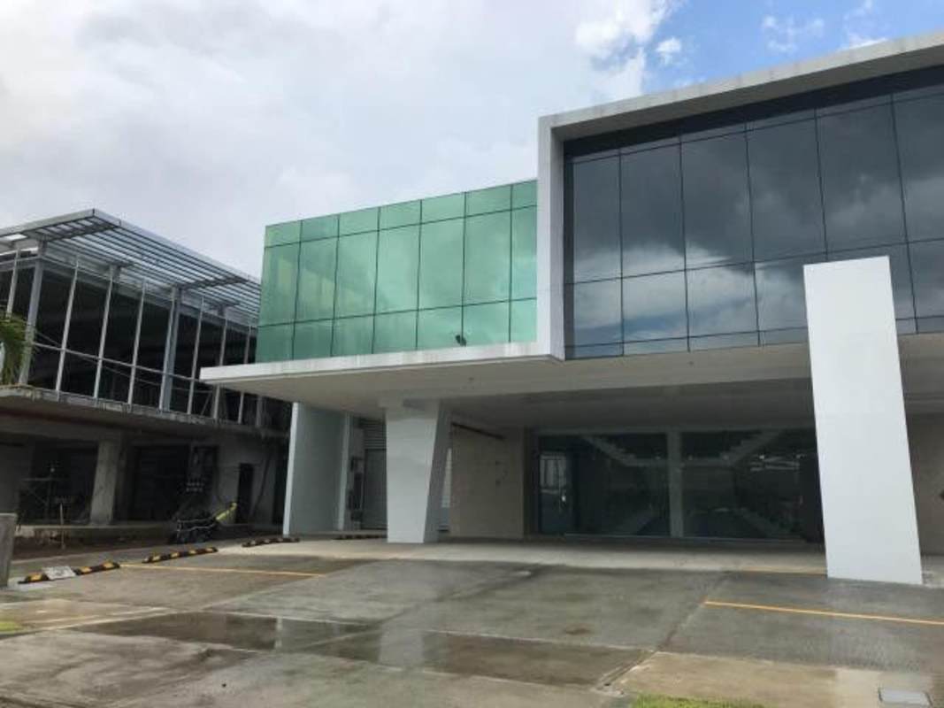 Glass facade with covered entrance and ample parking at Parque Lefevre commercial complex