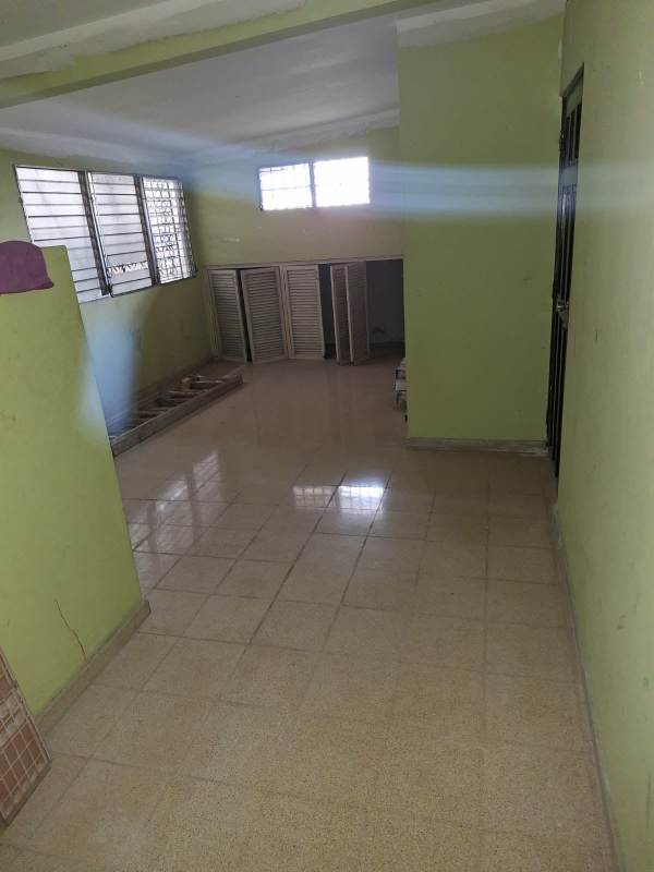 Kitchen with tiled flooring, wooden cabinets, barred window remodel ready in Betania rental house