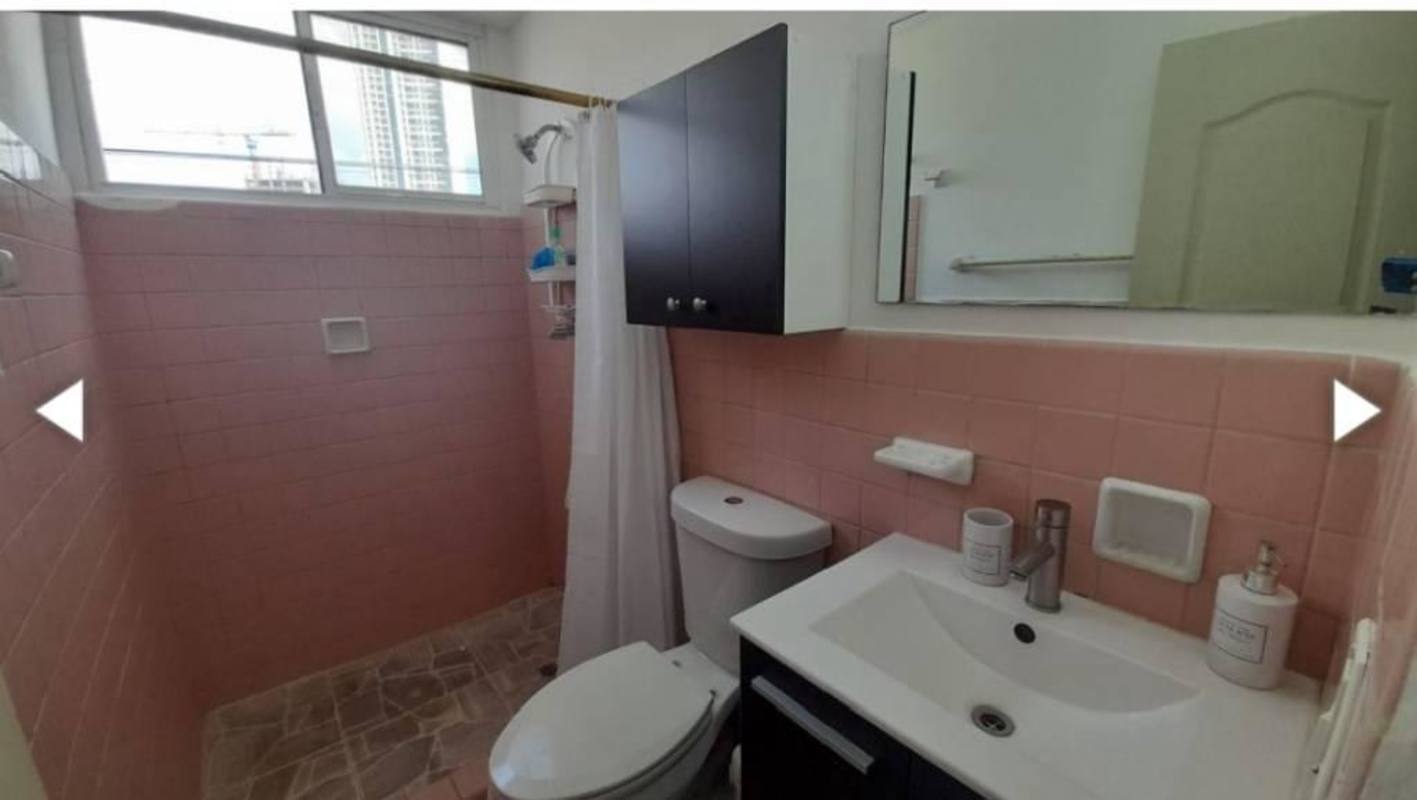 Bathroom with pink tiles, shower, window, vanity and mirror in PH Vista Hermosa apartment Panama City