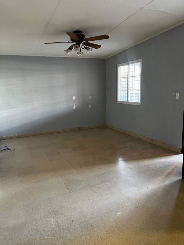 Bright living room with blue walls, tiled floors, ceiling fan in house for rent El Dorado Panama