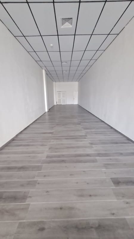 Sunny empty commercial floor in Plaza El Dorado with drop ceiling tiles and white walls