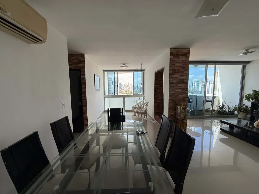 Open-plan living dining area with balcony access overlooking city and ocean Infinity Tower Panama