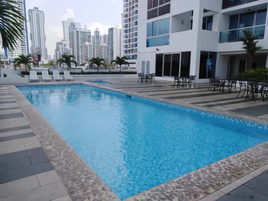 Rooftop pool deck with lounge chairs and city view in PH Infinity Tower San Francisco Panama