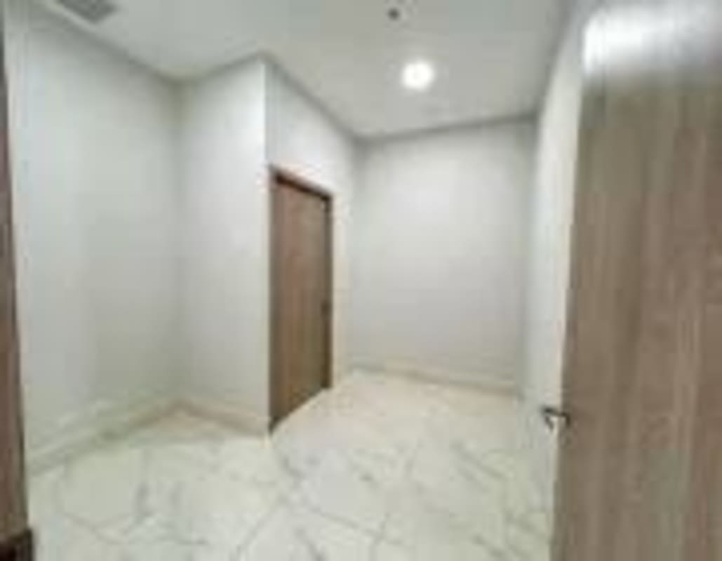 Minimalistic hallway with marble flooring and wooden doors at PH Town Center Panama