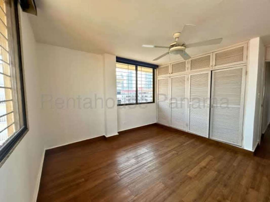 Bedroom featuring large windows, built-in closets and wood floors Panama apartment